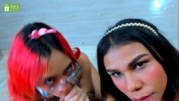 Two beauties share a throbbing treat—your view, their lips, pure ecstasy.
